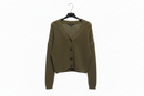 Green cardigan on a hanger against a white background