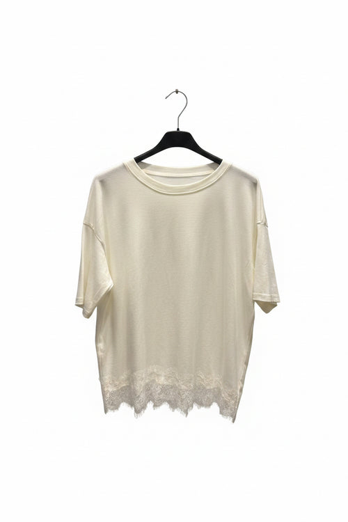 Beige lace-trimmed top on a hanger against a white background