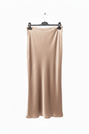 Beige satin skirt on a hanger against a white background