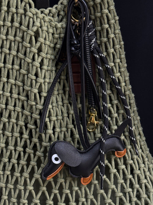Playful dachshund keychain with eco-leather details, brown accents and gold-tone hardware. A cute statement accessory for bags, keys or backpacks.