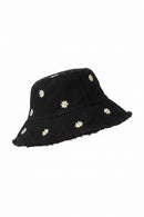 Black hat with white daisy flowers on a door