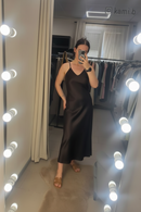 Person wearing a brown dress in a room with a mirror and lights.