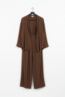 Brown jumpsuit on a hanger against a white background