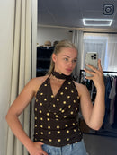 Person wearing a brown dress with white polka dots taking a mirror selfie.