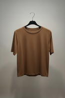 Brown t-shirt on a black hanger against a plain background