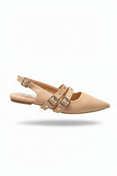 Beige pointed-toe shoes with buckles held by a hand in an indoor setting.