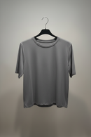 Gray t-shirt on a black hanger against a gray background