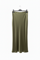 Green satin skirt on a hanger against a white background