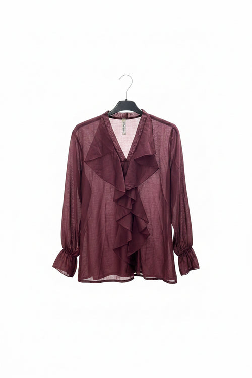 Maroon blouse with ruffled details on a hanger against a white background