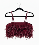Maroon feathered top on a black hanger against a white background