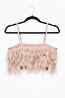 Pink feathered top on a black hanger against a white background