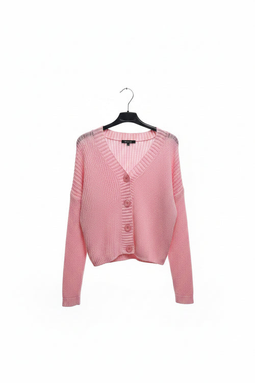 Pink cardigan on a hanger against a white background