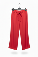 Red pants on a hanger against a white background