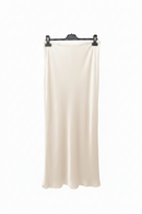 White skirt on a black hanger against a white background